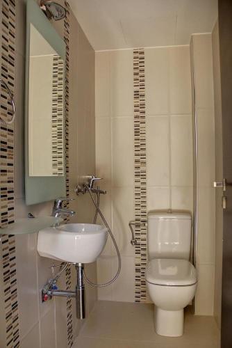 a bathroom with a toilet and a sink at PALM BEACH HOME in Agia Pelagia