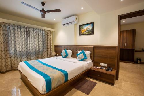 a bedroom with a large bed and a ceiling fan at Hotel Hangout in Pune