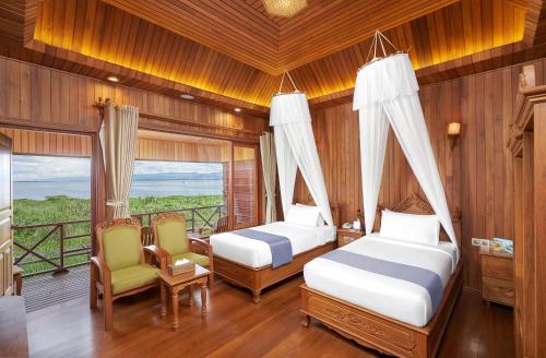 a bedroom with two beds and a balcony at KMA Inle Hotel in Nyaung Shwe