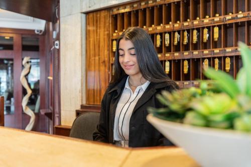 a woman sitting at a counter in a restaurant at Hotel Continental Frankfurt in Frankfurt/Main