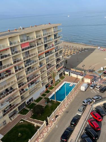 duży budynek z parkingiem i plażą w obiekcie Torremolinos,estudio junto al mar en La Carihuela w mieście Torremolinos