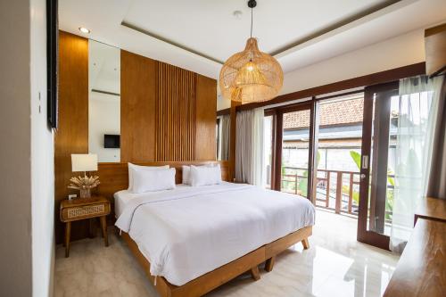 um quarto com uma cama grande e um lustre em Tamantara em Ubud