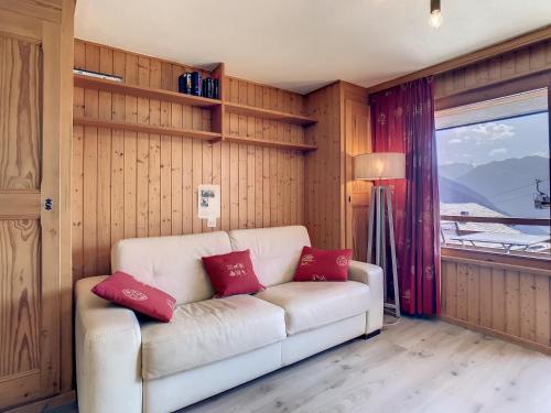 a living room with a white couch with two red pillows at Emeraude 319 in Verbier