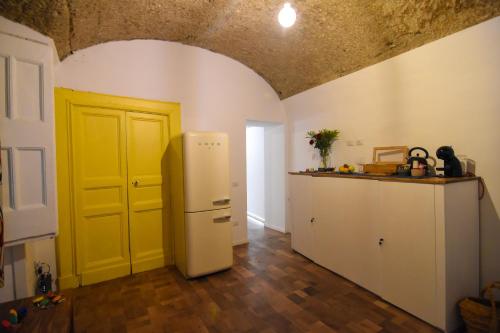 una cucina con frigorifero bianco e porta gialla di La Dimora di Artemide B&B a Napoli