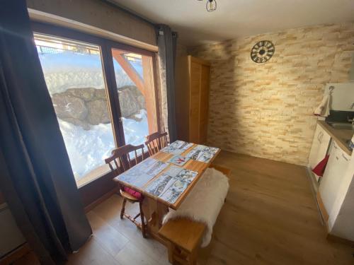 une salle à manger avec une table et une fenêtre dans l'établissement Chaleureux appartement rénové ambiance chalet, à Praz-sur-Arly