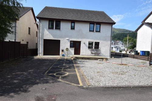 ロッホゴイルヘッドにあるRidgeview Villa - Partial loch viewの車道のガレージ付白い家