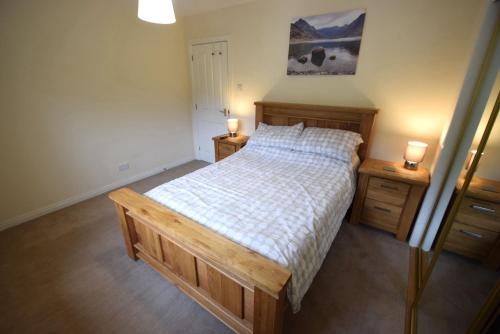 a bedroom with a bed with two night stands and two lamps at Ridgeview Villa - Partial loch view in Lochgoilhead