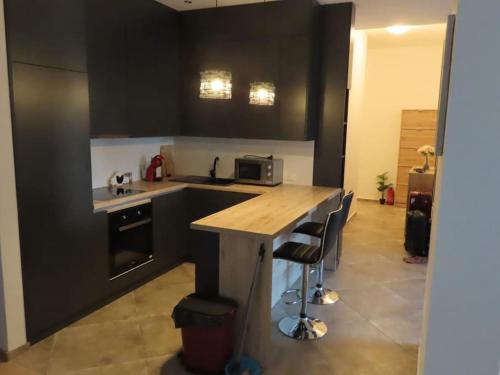 a kitchen with black cabinets and a counter with stools at Montenegro Royal 2 Bedroom Apartment in Becici