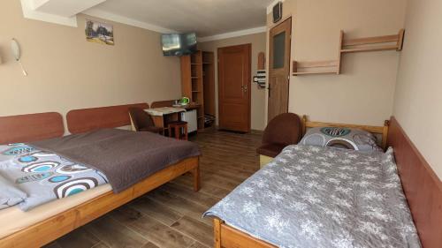 a small room with two beds and a table at Baltazar in Łeba