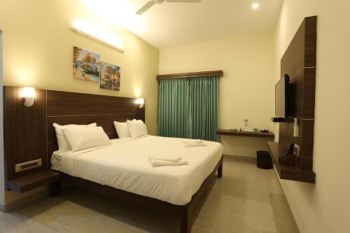 ein Schlafzimmer mit einem großen Bett mit einem grünen Vorhang in der Unterkunft Minas Manor in Tiruchchirāppalli