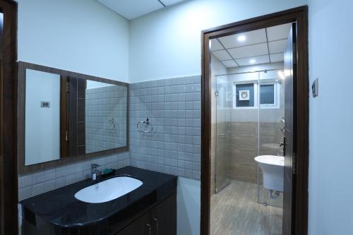 ein Badezimmer mit einem Waschbecken, einem WC und einem Spiegel in der Unterkunft Minas Manor in Tiruchchirāppalli