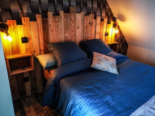 a bedroom with a blue bed with a wooden wall at L'Effet Mer, maison d'exception in Berck-sur-Mer