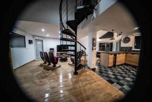 a living room with a spiral staircase in a house at L'Effet Mer, maison d'exception in Berck-sur-Mer