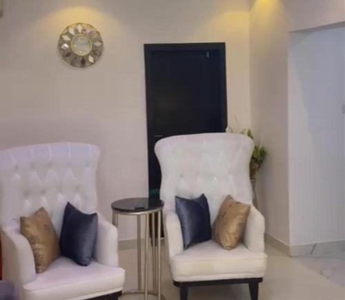 two white chairs and a table in a room at Immaculate 2-Bed Apartment in Lekki Ajah in Lekki