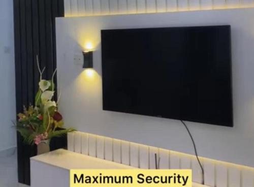 a flat screen tv hanging on a white wall at Immaculate 2-Bed Apartment in Lekki Ajah in Lekki