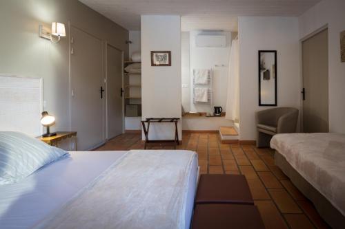 ein Schlafzimmer mit einem Bett und ein Wohnzimmer in der Unterkunft Logis des Magnans - le Murier - in Sauve