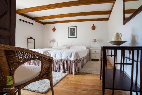 a bedroom with two beds and a chair at Quinta da Bouça - Agroturismo in Paços de Gaiolo