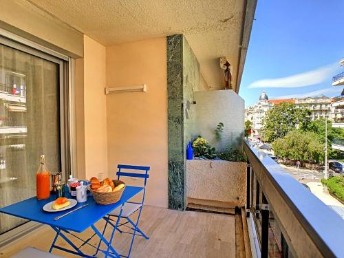 d'un balcon avec une table et des chaises bleues et un réfrigérateur. dans l'établissement BLUE RIVIERA TERRACE CENTRAL TRAIN STATION, à Nice