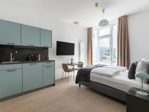 a bedroom with a bed and a kitchen with a table at limehome Berlin Luise Henriette Str - Digital Access in Berlin