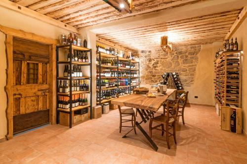 une salle à manger avec une table et des étagères de bouteilles de vin dans l'établissement 13 Comuni Ristorante E Albergo, à Velo Veronese