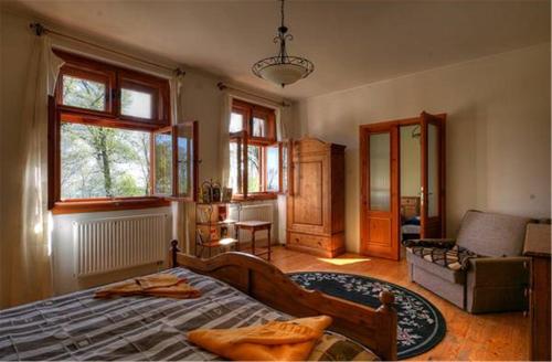 クーセグにあるKeresztkúti Erdei Pihenőhelyのベッドルーム1室(ベッド1台、ソファ、窓付)