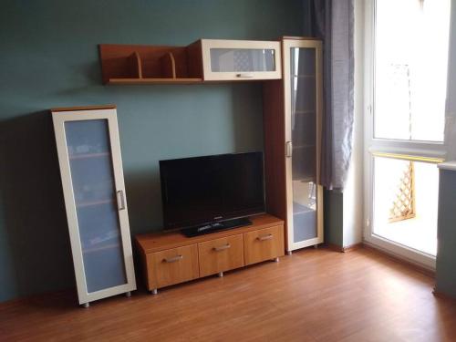 a living room with a flat screen tv on a wooden cabinet at Apartament z widokiem na Zatokę, Hel, Port i lasy in Gdańsk