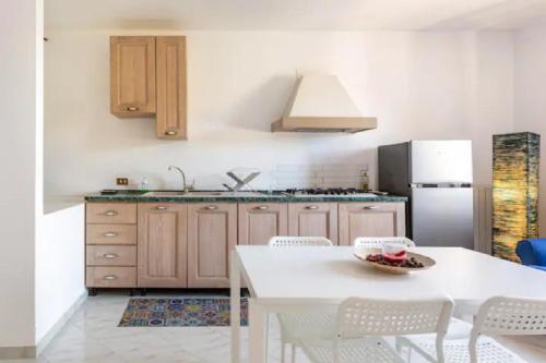 a kitchen with a white table and a refrigerator at Villa Mariel Suites & Apartment in Massa Lubrense
