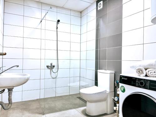 a white bathroom with a toilet and a sink at Luxury apartment Struga in Struga