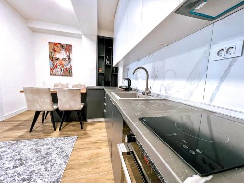 eine Küche mit einem Waschbecken und einem Tisch in der Unterkunft Luxury apartment Struga in Struga
