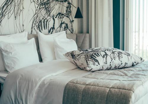 a white bed with a pillow on top of it at Hotel AX in Helsinki