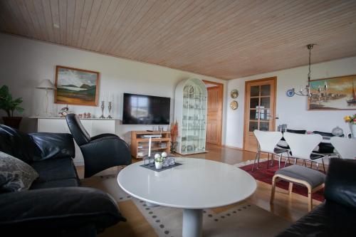 un salon avec une table et des chaises blanches dans l'établissement 4 Bedroom Apartment - 20 Min Walk From City Centre - Nature, à Tórshavn