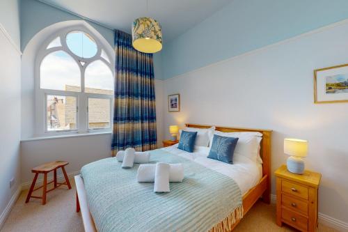 sypialnia z dużym łóżkiem i oknem w obiekcie Church Mews w mieście Exmouth
