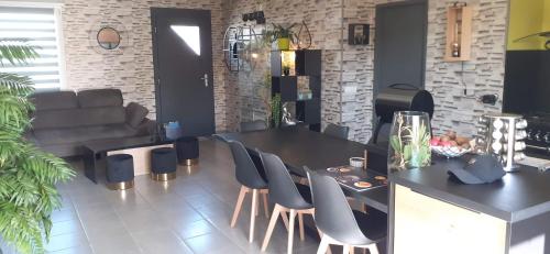 een woonkamer met een tafel en stoelen en een bank bij chambre moderne en campagne in Le Calvaire