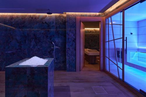 a bathroom with a tub and a glass door at Castello Infinity Suites - Adults Only in Agia Pelagia