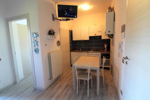 uma pequena cozinha com mesa e cadeiras num quarto em Casa Francia em Follonica