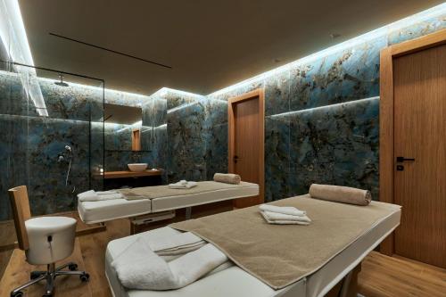 a bathroom with two beds and a sink and a mirror at Castello Infinity Suites - Adults Only in Agia Pelagia