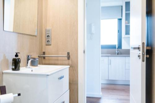 baño blanco con lavabo y cocina en Moderno apartamento con Piscina y Parking, en Granada