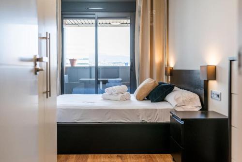 a bedroom with a bed with towels on it at Moderno apartamento con Piscina y Parking in Granada