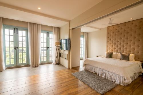 a bedroom with a large bed and large windows at Villa Donna in Dona Paula
