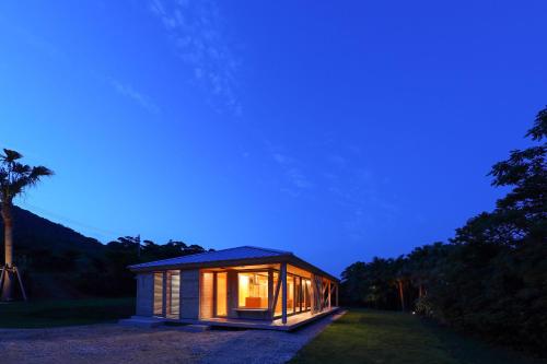 a small house is lit up at night at 泊まれるアートミュージアム 琉球ヴィラ in Tatsugo