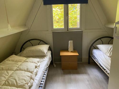 2 camas en una habitación con 2 ventanas en La Dolce Vita, Chalet 75, Vakantiepark Sunclass Durbuy, en Durbuy