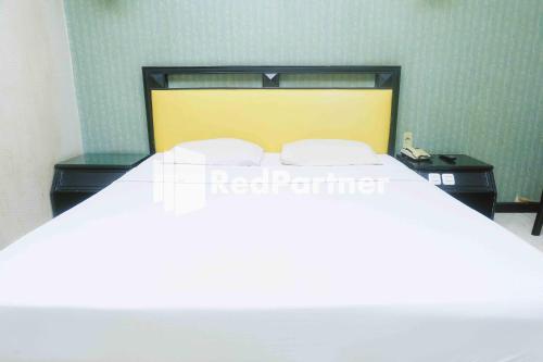 Urbanview Hotel Yasmin Makassar by RedDoorzにあるベッド