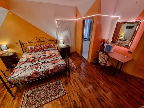 1 dormitorio con cama, escritorio y espejo en La MAISON B&B, en Ceccano
