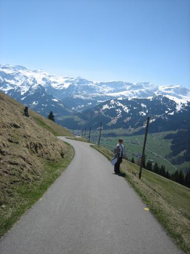 a couple standing on a road in the mountains at Schweiz ,Lenk Ferienwohnung,Kinderfreundl,Seniorenfreundlich in Lenk