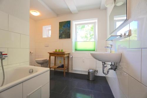 a bathroom with a sink and a tub and a toilet at Ferienwohnung Krabbe in zentraler Lage von Eckernförde in Eckernförde