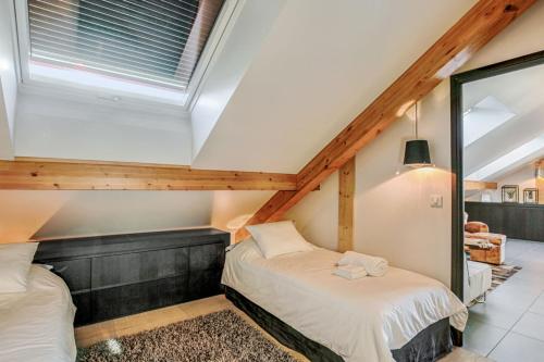 two beds in a attic bedroom with a window at Beautiful 3-rooms flat Terrace - Sun - Calm in Annecy-le-Vieux