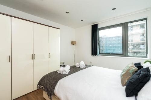 a white bedroom with a bed and a window at Lovely one bedroom apartment in Greater London, ID required in London