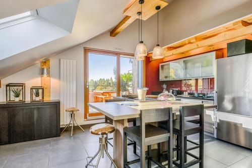 - une cuisine avec un grand îlot de cuisine avec des tabourets dans l'établissement Panorama du Bellay - Welkeys, à Annecy-le-Vieux