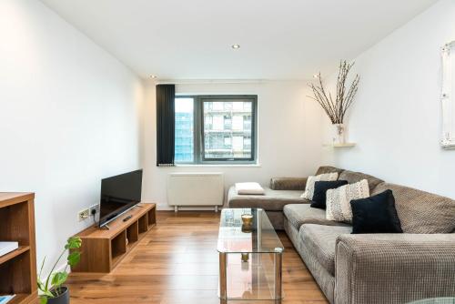 a living room with a couch and a tv at Direct Tube Links to Central London , Walk to Station one bedroom flat in Greater London, ID required in London