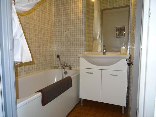 La salle de bains est pourvue d'un lavabo, d'une baignoire, d'un lavabo et d'un miroir. dans l'établissement F2 Mezzanine avec Piscine, Parking et Climatisation à Palavas, Proche Plage et Centre-Ville - FR-1-559-8, à Palavas-les-Flots